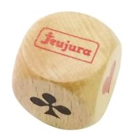 Photographie sur fond blanc d'un dé d'atout en bois naturel. La face supérieure met en évidence le logo de la marque "Jeujura" imprimé en rouge à l'intérieur d'un encadré. Les faces latérales dévoilent les symboles classiques des cartes à jouer : on y dis
