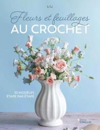Couverture du livre Fleurs et feuillages au crochet avec bouquet de fleurs crochetées délicates dans un vase blanc sur fond bleu pastel, ambiance douce et élégante. Achat sur Divertistore.com.
