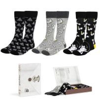Coffret cadeau Harry Potter avec chaussettes à motifs des Reliques de la Mort, d’Hedwige et de Harry Potter, présenté dans une boîte blanche inspirée d’une lettre de Poudlard.