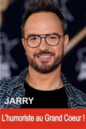 Couverture du livre "JARRY : L'humoriste au Grand Cœur !". On y voit un portrait photographique de l'humoriste Jarry de face, souriant chaleureusement. Il porte des lunettes de vue à monture fine, une petite barbe soignée, un t-shirt noir et une veste en 