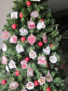 Calendrier de l’Avent Cousines & Compagnie terminé : 25 décorations brodées en feutrine suspendues sur un sapin de Noël, représentant des motifs festifs comme cœurs, étoiles, rennes et cadeaux.